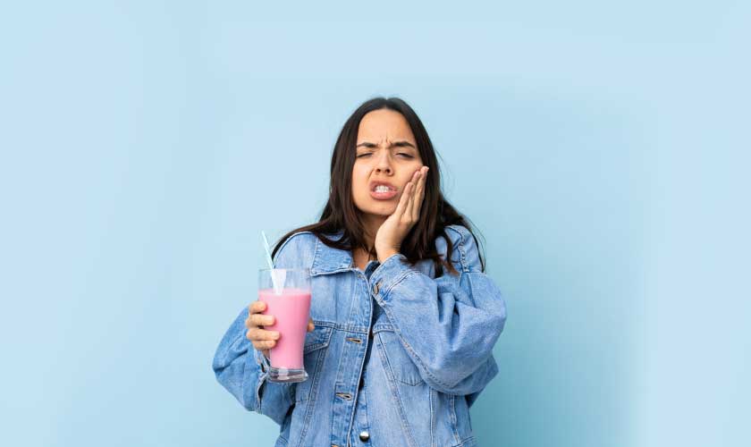 strawberry milkshake over isolated blue wall with toothache_img